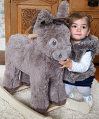 Grey plush rocking donkey with cute face and handles, toddler kneeling beside