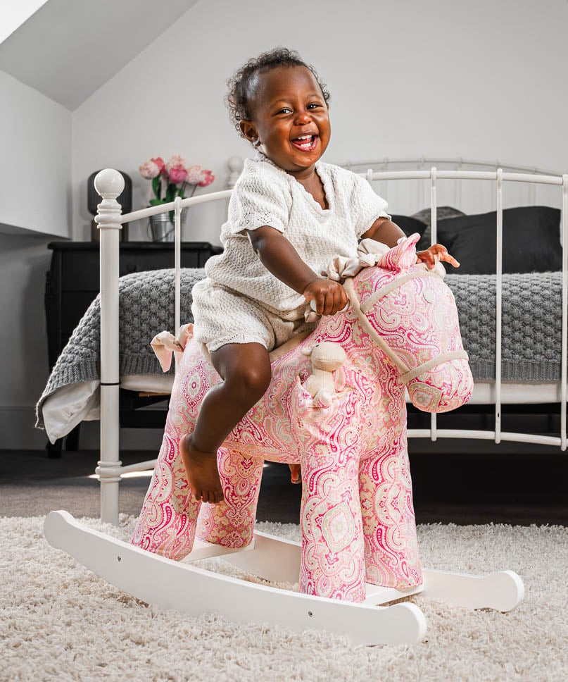 Pink paisley plush rocking horse with white wooden rocking base 