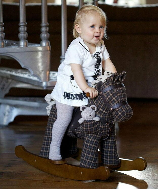 Little girl riding Rufus & Ted Rocking Horse with luxury plaid brown woven fabric