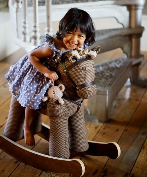 Little girl riding on Chester & Fred Rocking Horse with sturdy wooden frame