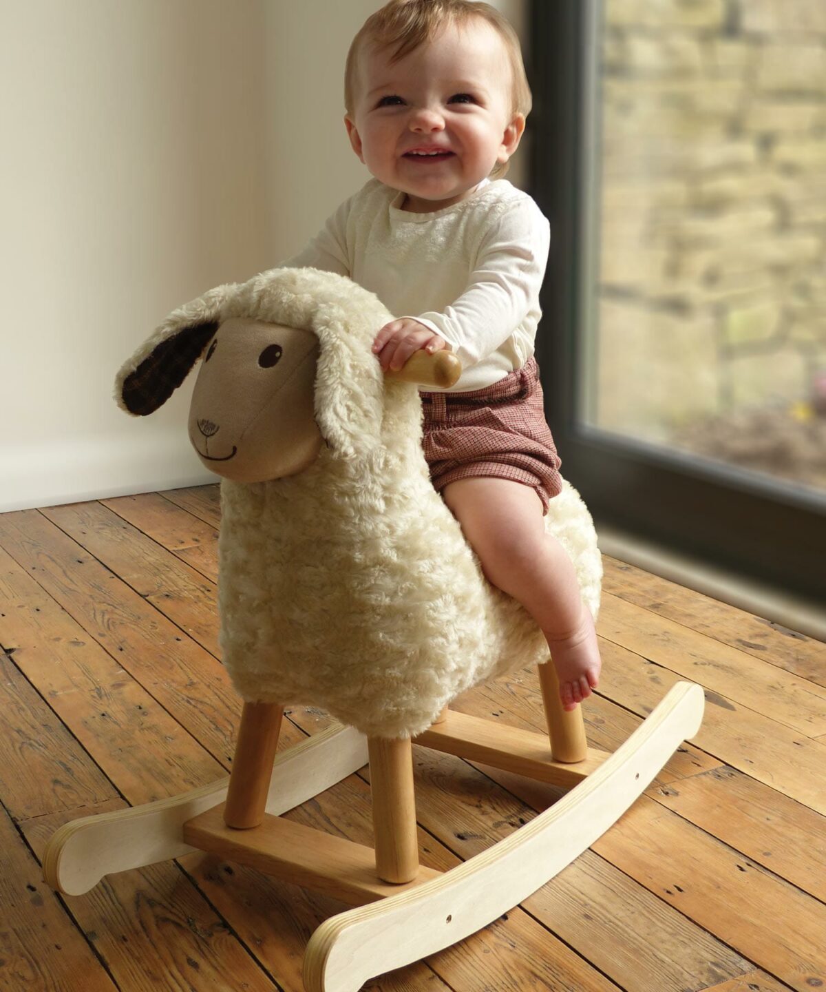 Baby Boy riding on Lambert Rocking Sheep with sturdy wooden frame