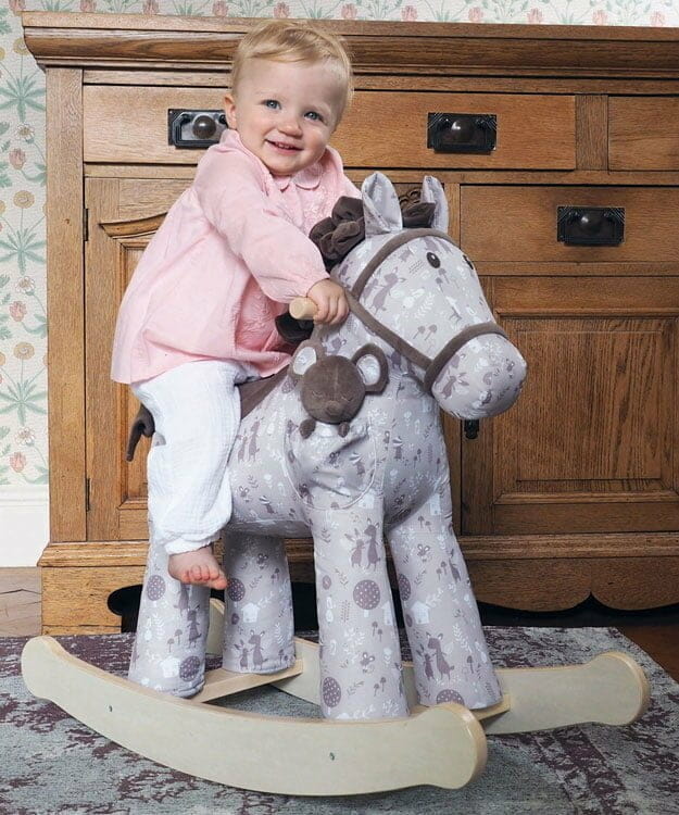 Little girl riding stylish Biscuit & Skip Rocking Horse
