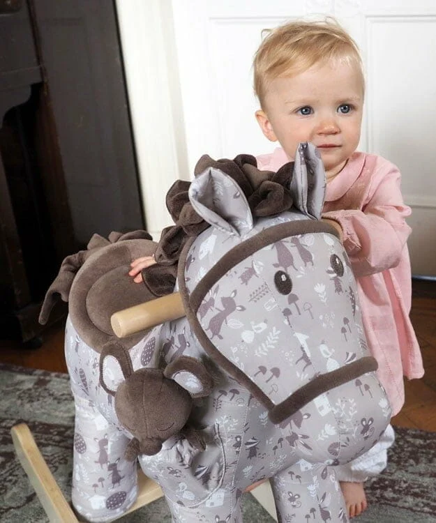Little girl playing with Biscuit & Skip Rocking Horse with soft velour saddle, mane and tail