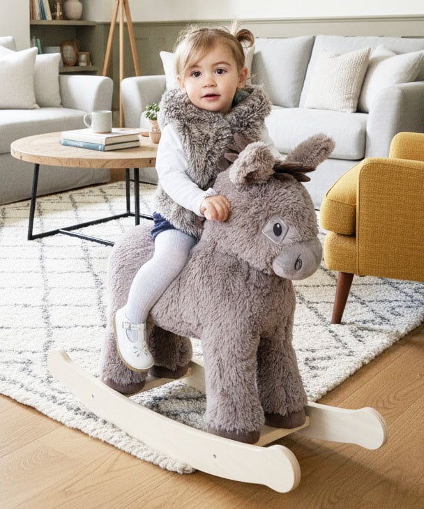 Little girl riding a rocking donkey toy