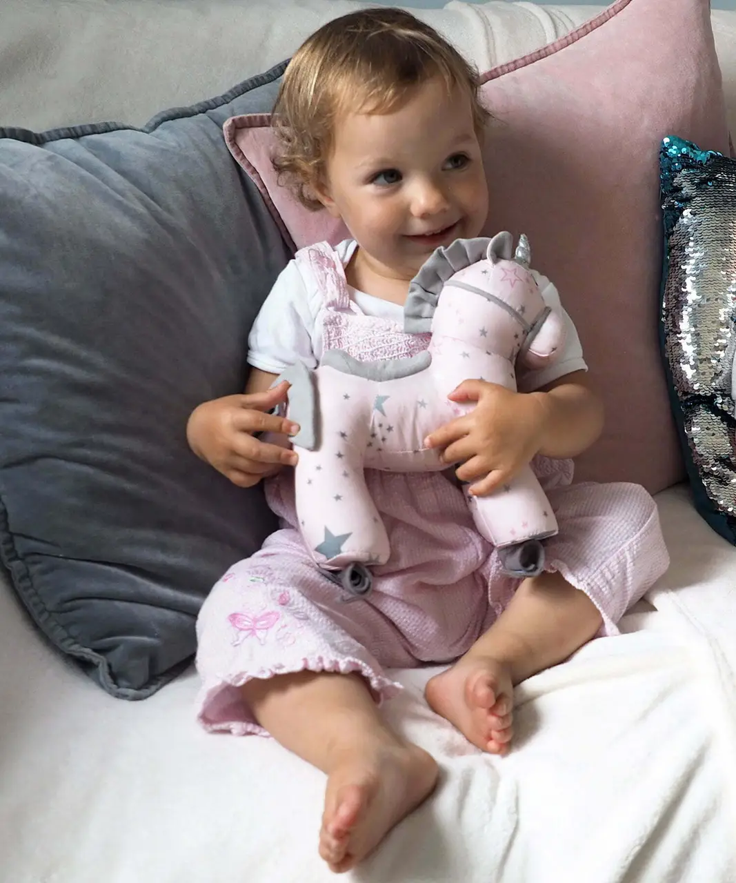 Baby Girl hugging Celeste Unicorn Pull Along Toy without wheels 