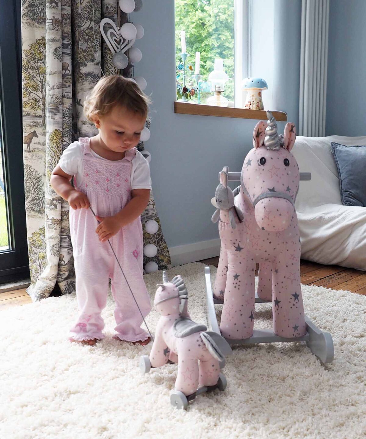 Toddler with Celeste Unicorn Pull Along Toy and Celeste Rocking Unicorn 