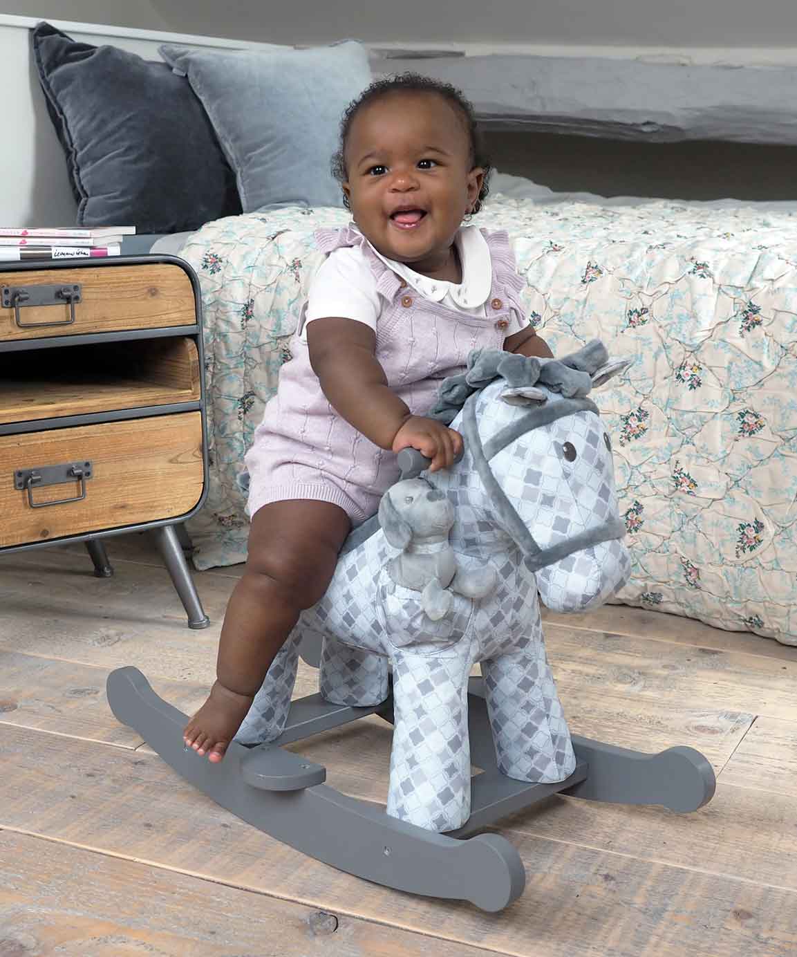 Baby Girl riding Harper & Chase Rocking Horse  featuring a grey geometric printed fabric 