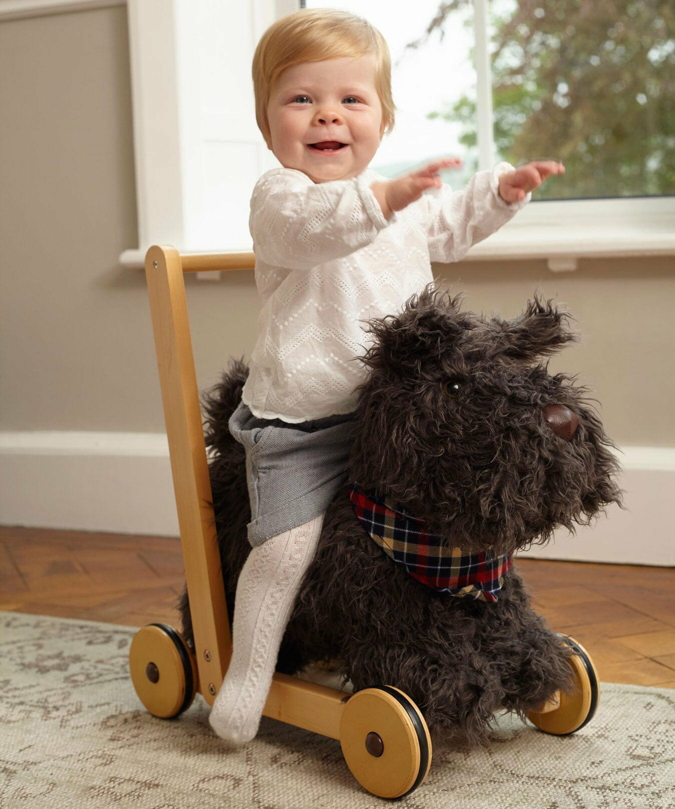 Little girl riding Scottie Dog Baby Walker with sturdy wooden frame