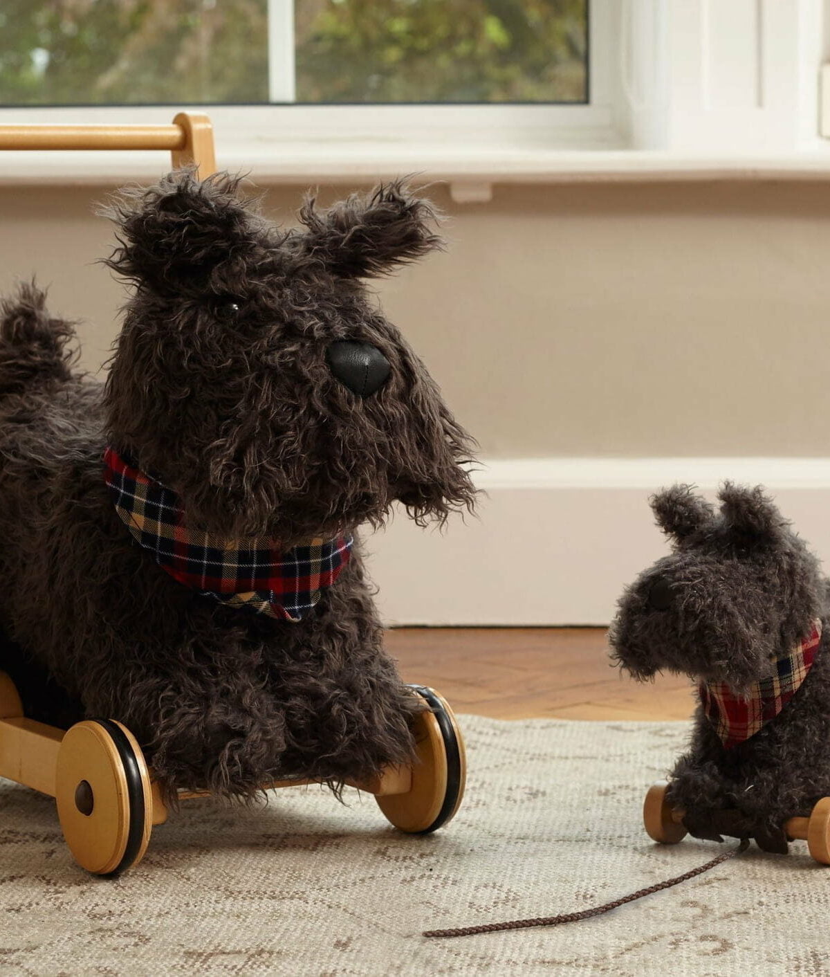 Scottie Dog Baby Walker and Scottie Dog Pull Along Toy standing on cream rug