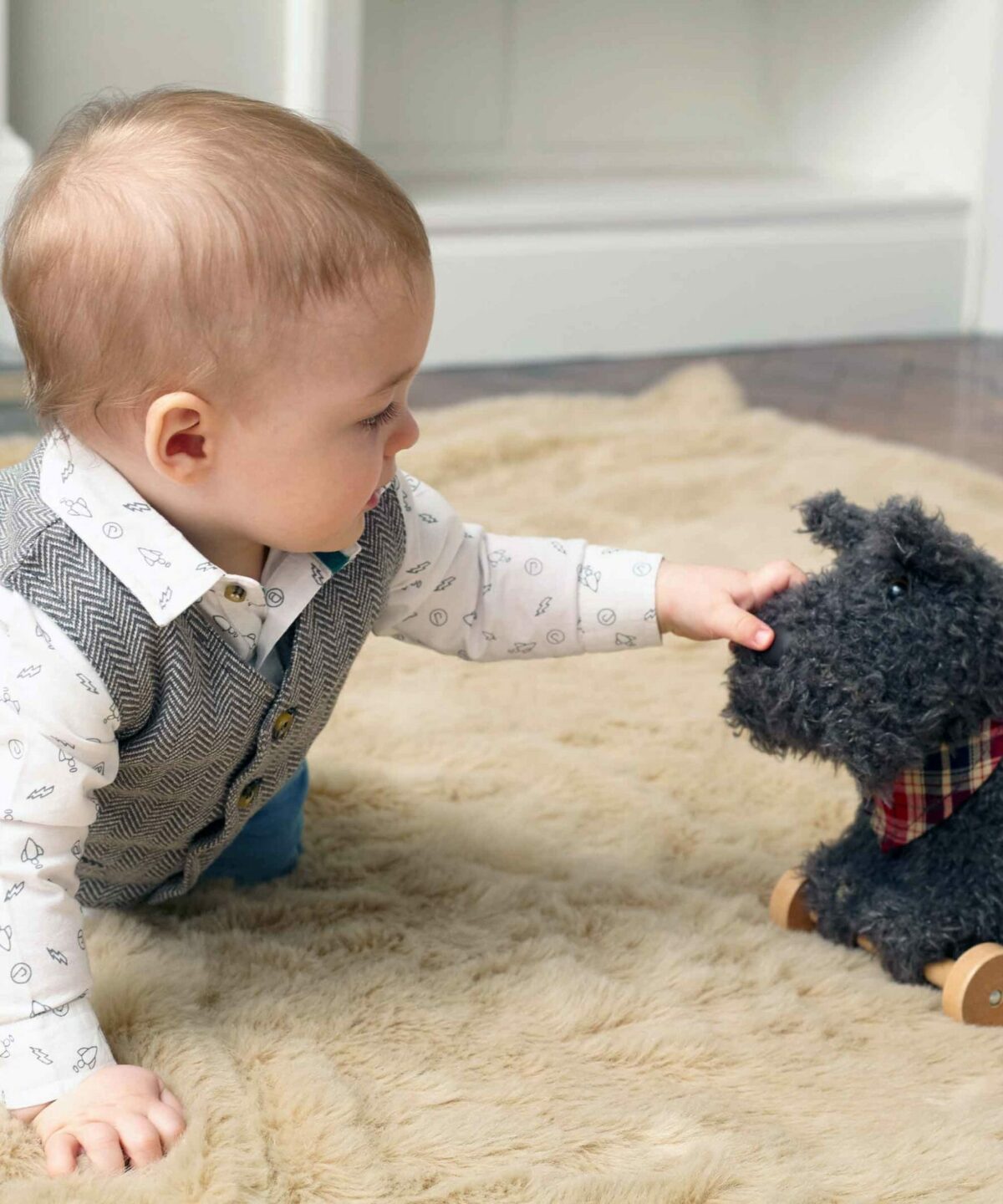Baby boy playing with Scottie Dog Pull Along Toy 