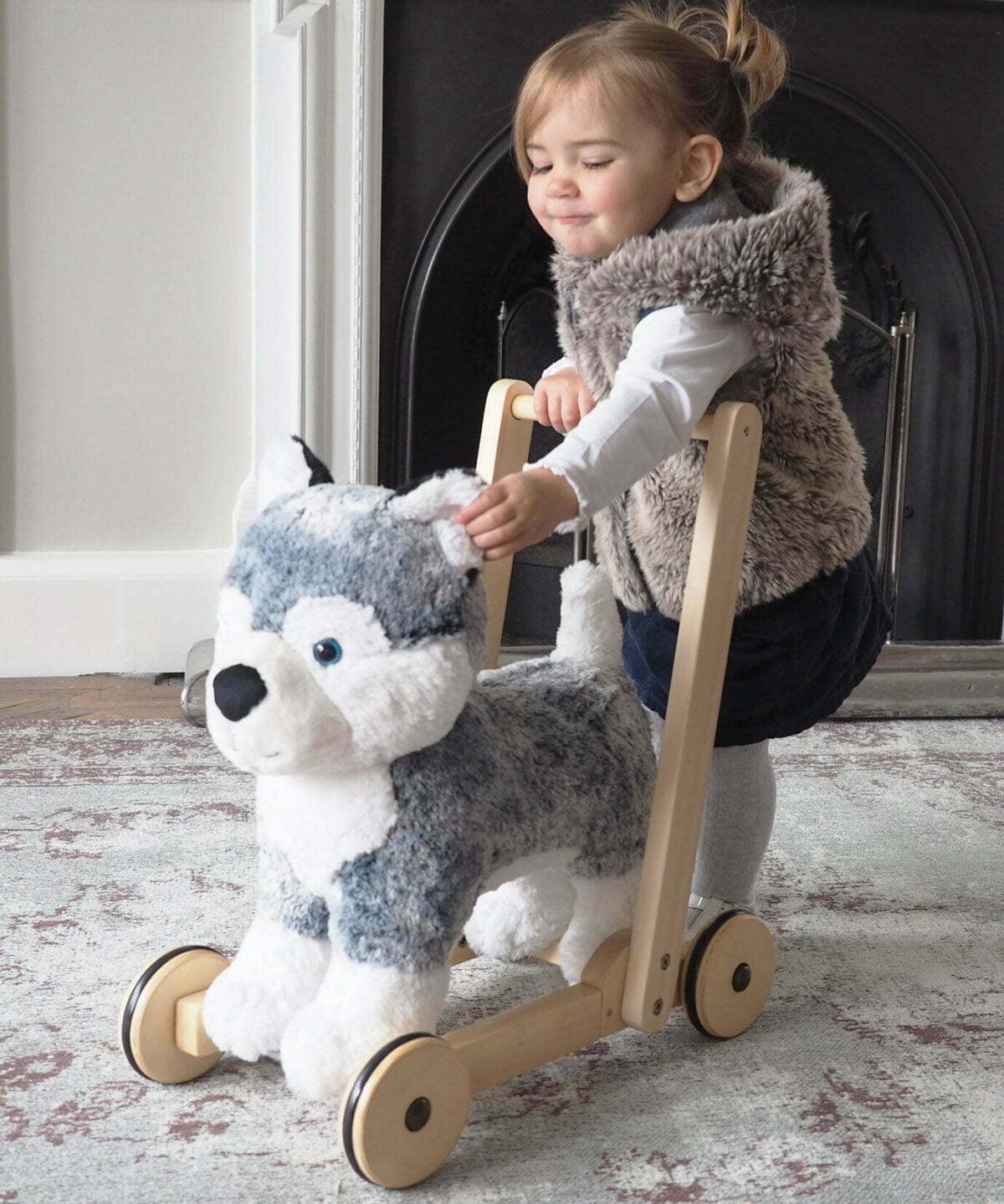 Little girl playing with Mishka Dog Baby Walker on wheels