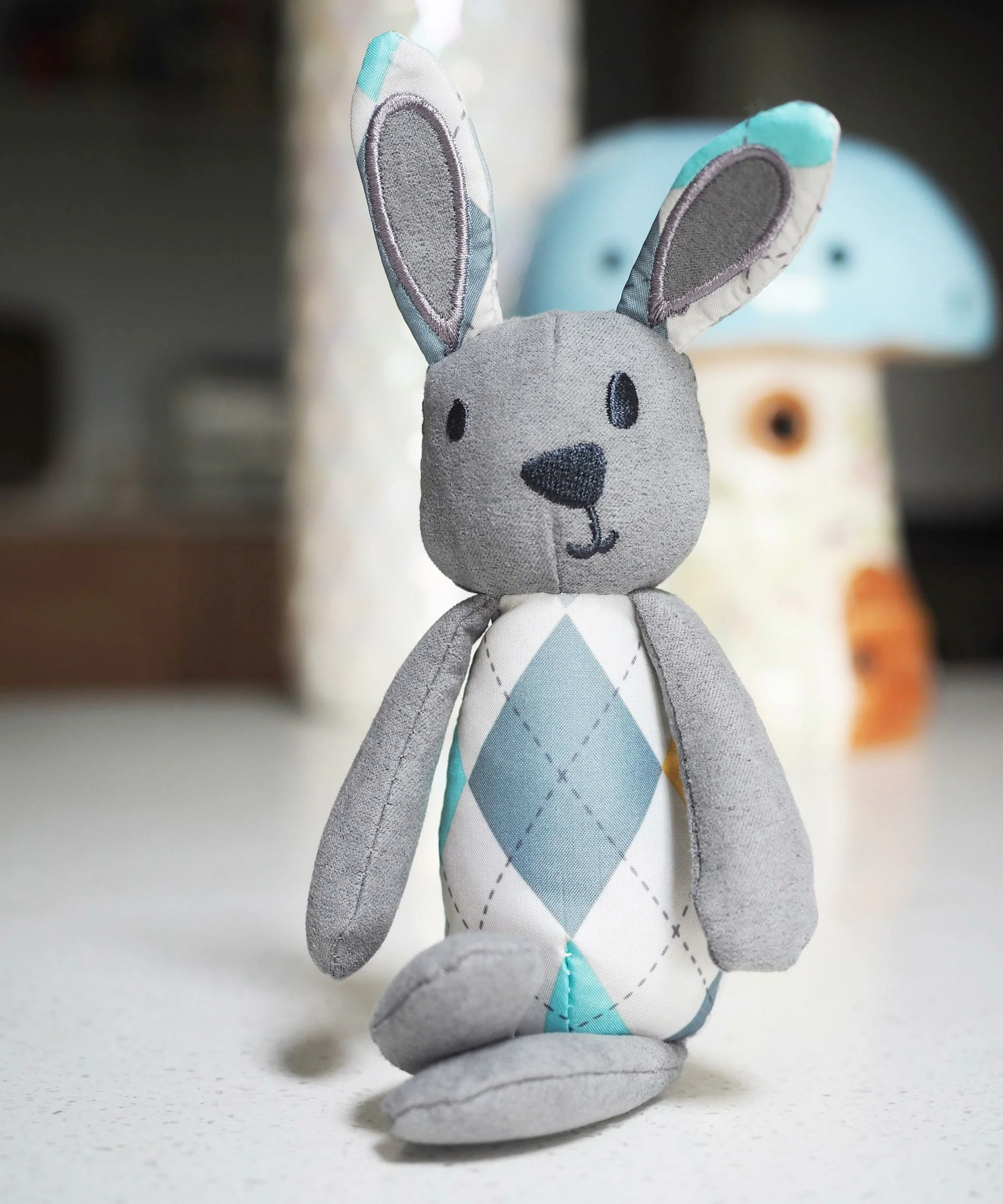 Little Fitz Rabbit sitting in front of a toadstool