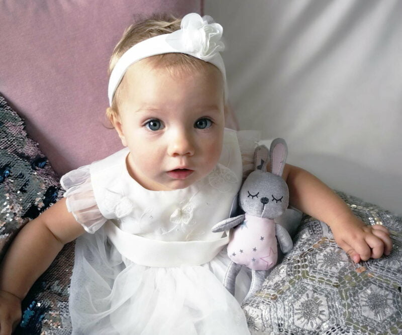 Little girl in white dress hugging Little Fae Fairy