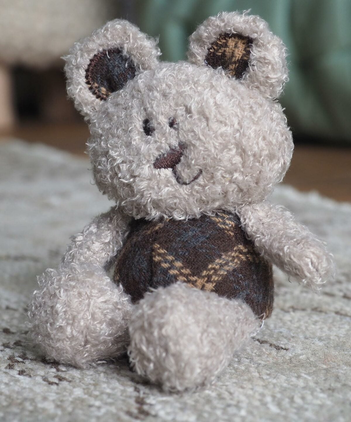 Little Ted Bear sitting on a rug