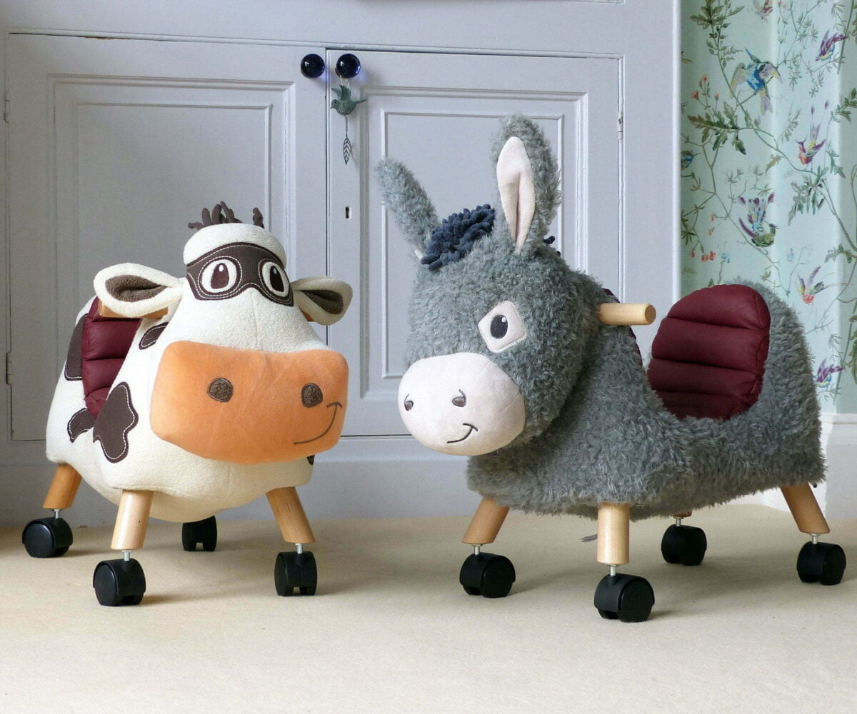 Moobert Cow Ride On Toy standing with Bojangles Donkey Ride On Toy