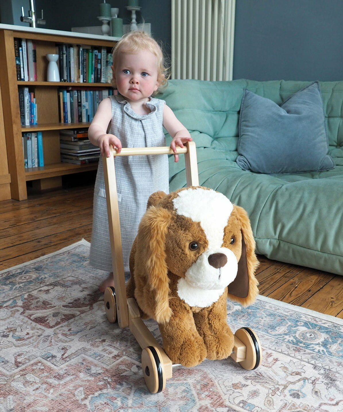 Little girl playing with Peanut Pup spaniel baby walker with wheels