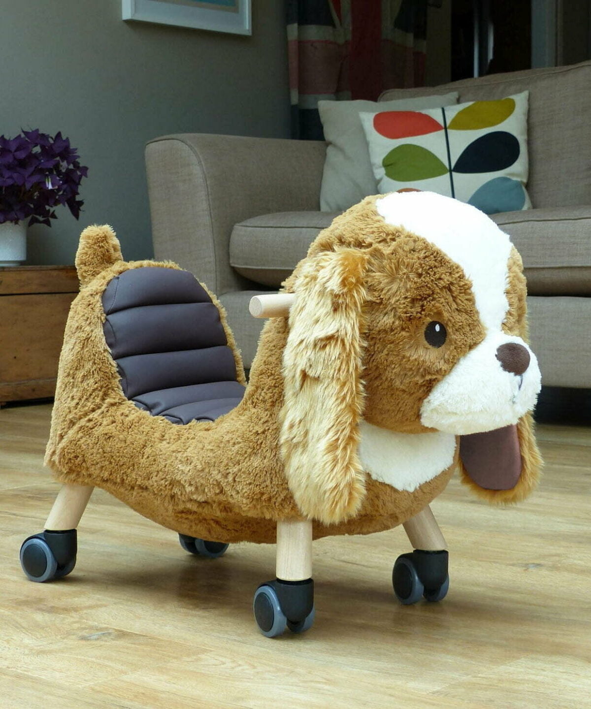 Side image of Peanut Pup Animal Ride on on wooden floor in living room 