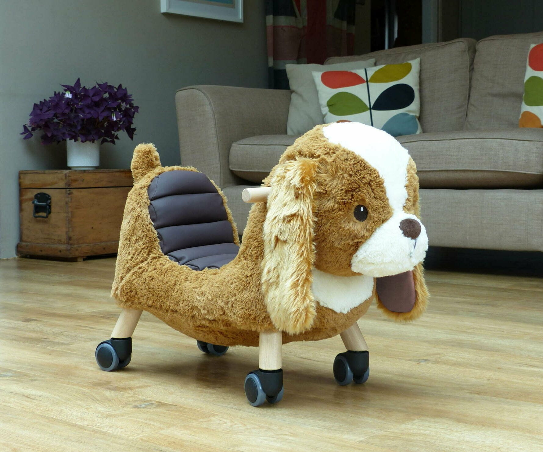 Side image of Peanut Pup Animal Ride on on wooden floor in living room 