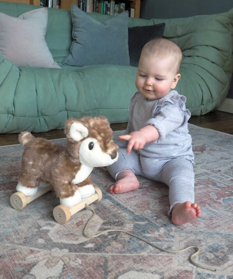 Little toddler girl playing with willow woodland animal pull along toy for babies and toddlers