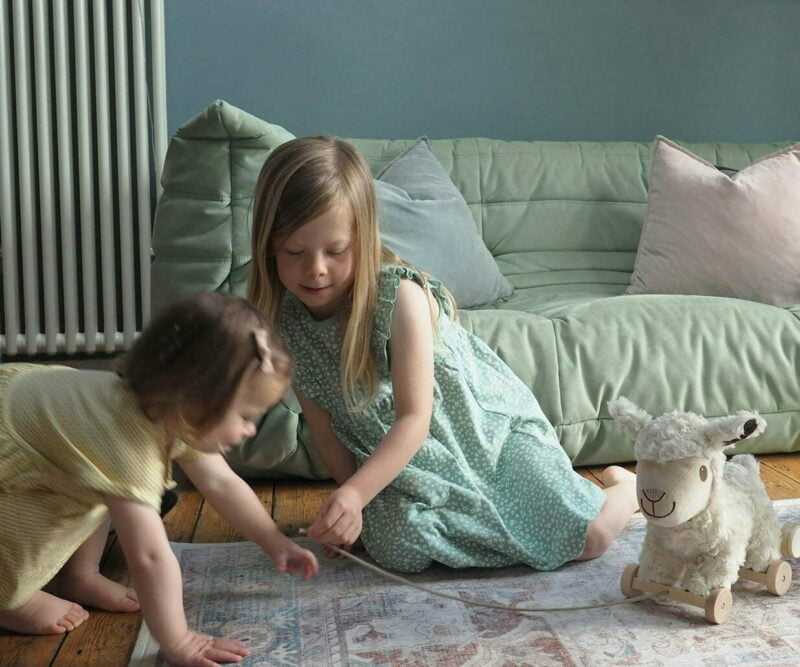 toddler girls playing with Lambert sheep teddy 