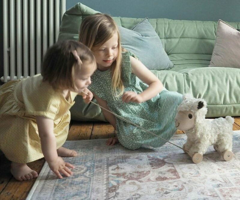 toddler girls playing with sheep teddy 