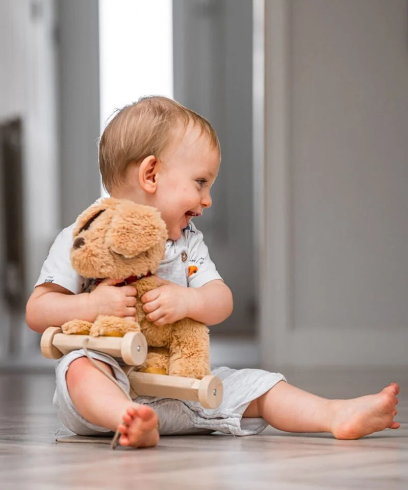 Little boy hugging dexter dog toy  