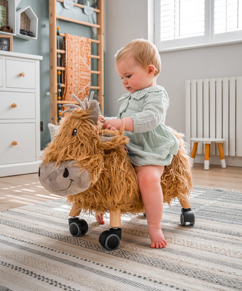 Girl playing on hubert highland cow ride on toy 