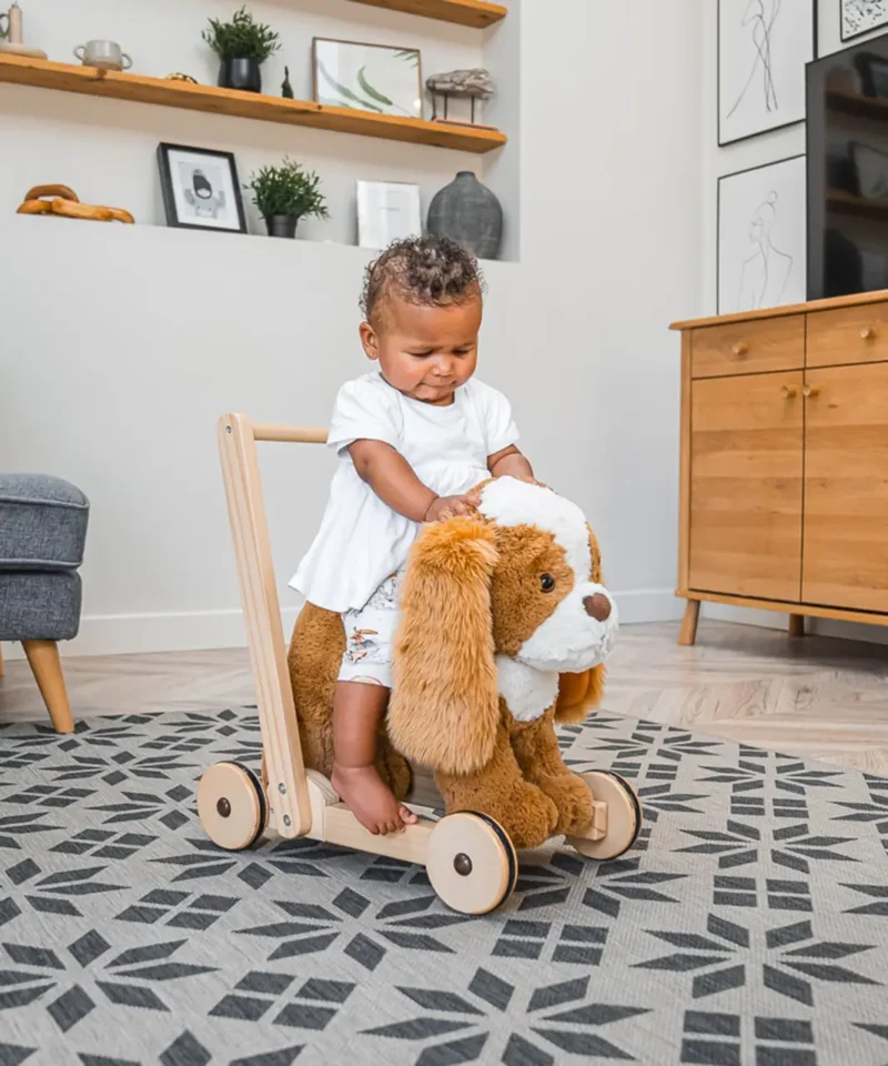 little girl sat riding peanut pup ride on baby walker