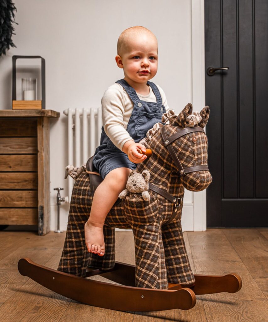 Boy riding a brown plaid rocking horse