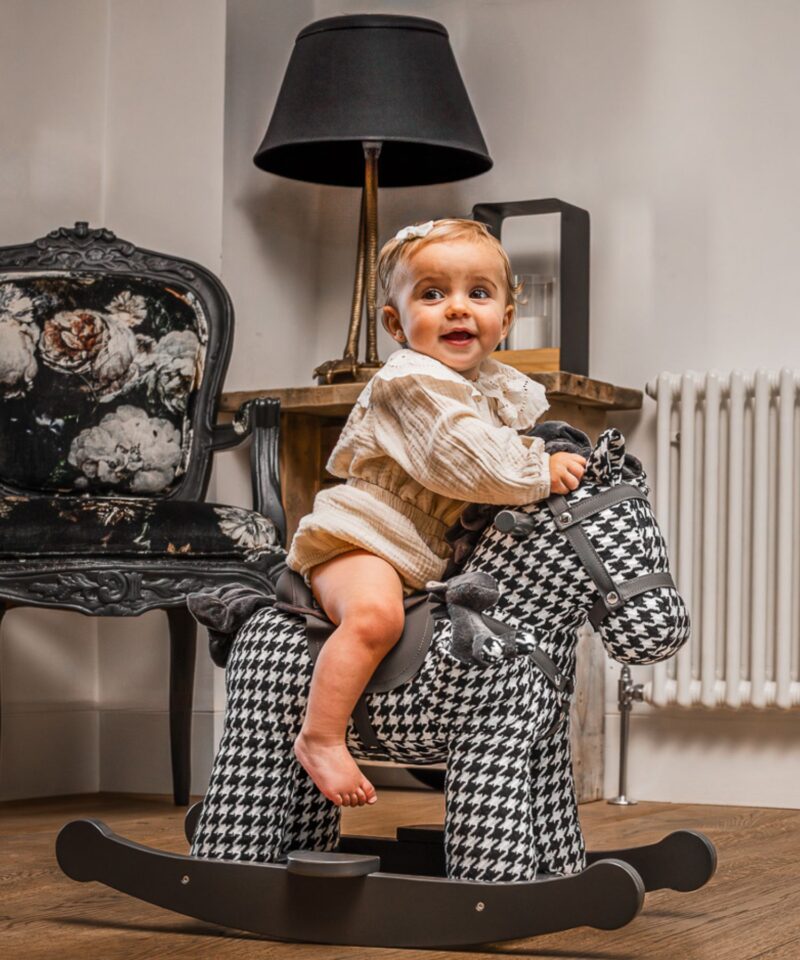 little girl on black and white printed rocking horse 