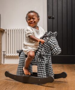 little girl on newborn black and white horse