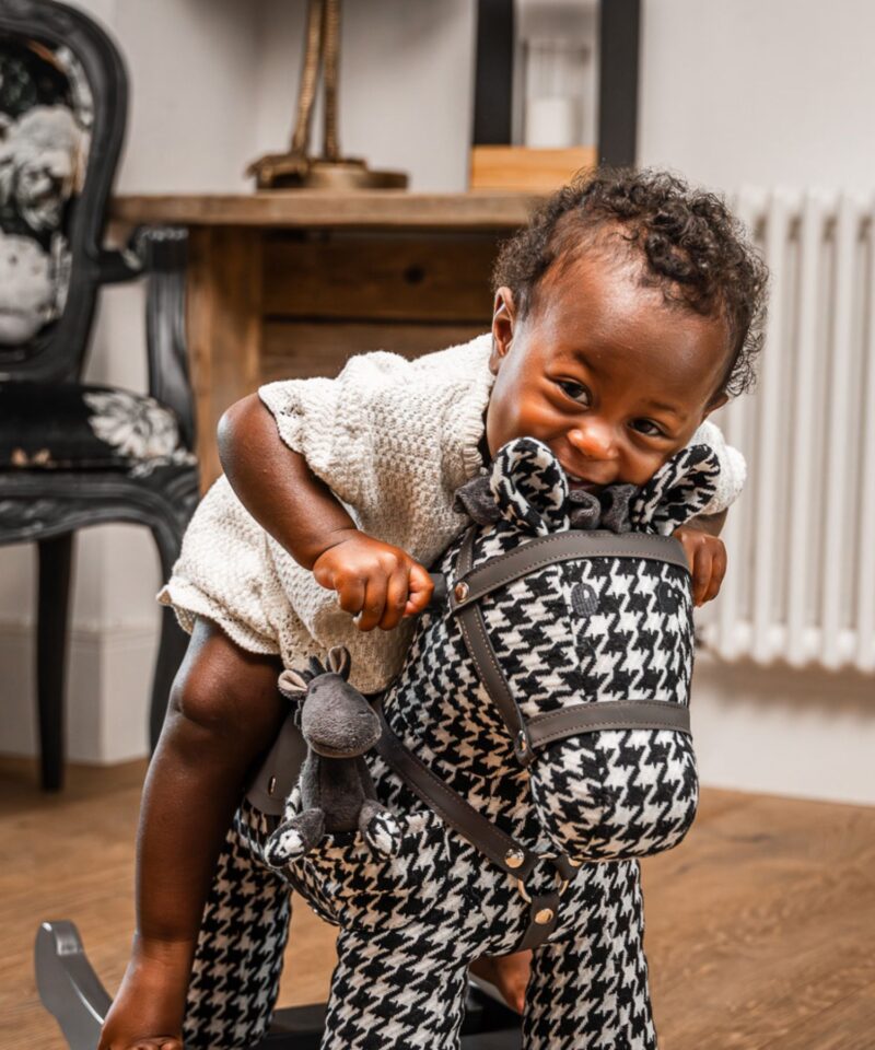 girl on toddler black and white rocking horse