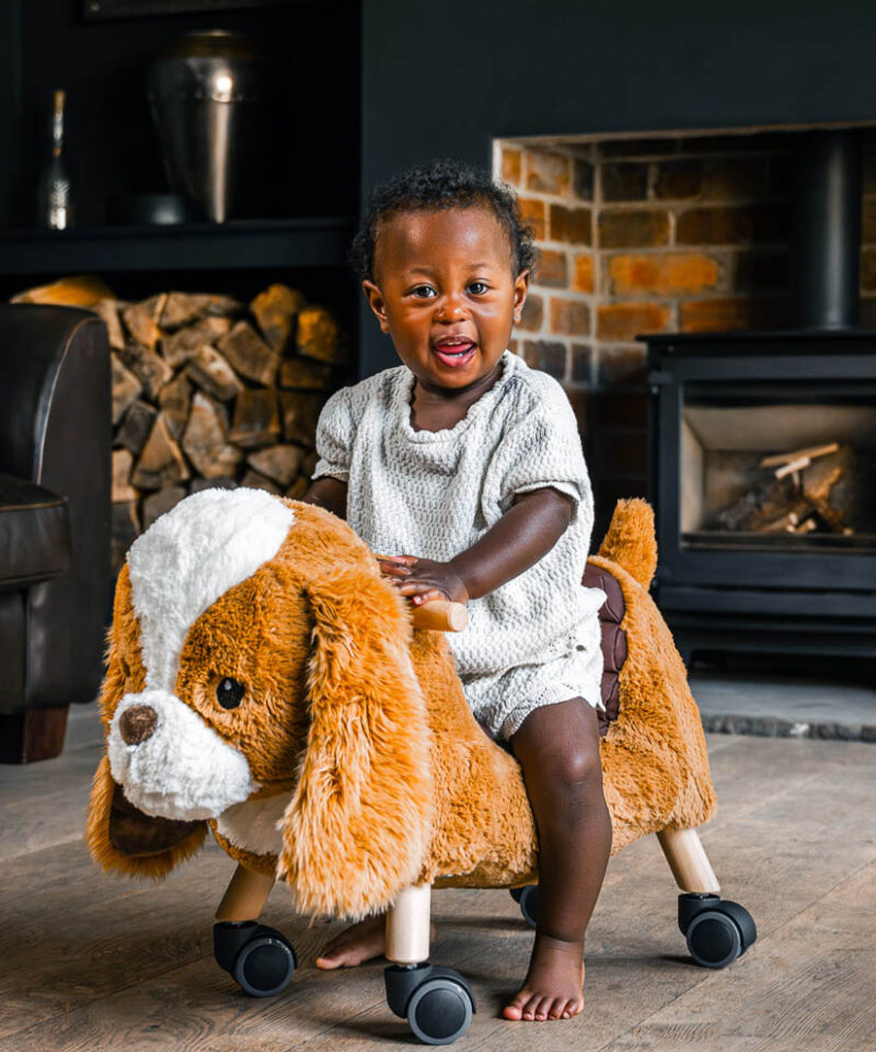 Little girl riding dog wheeled toy