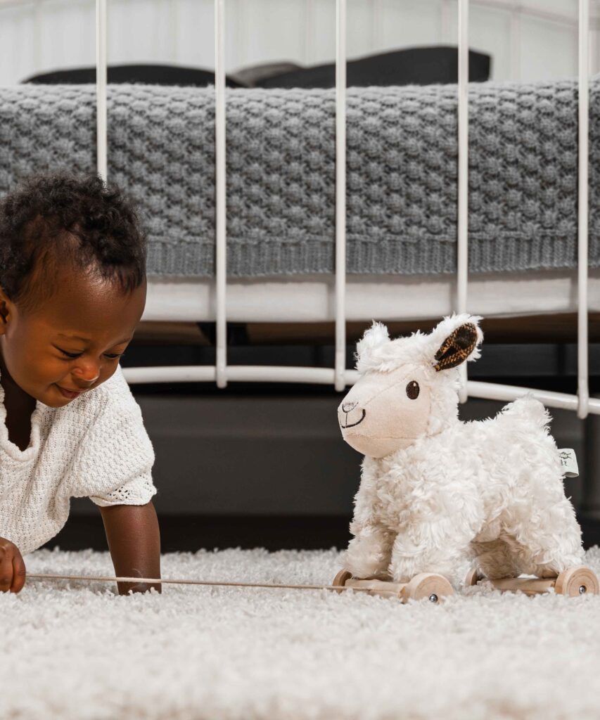 Toddler playing with Lamb pull toy