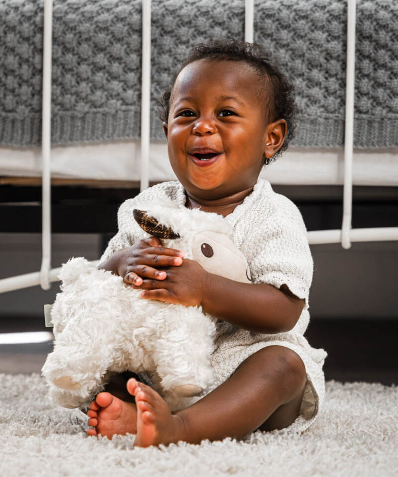 Little girl hugging lamb toy