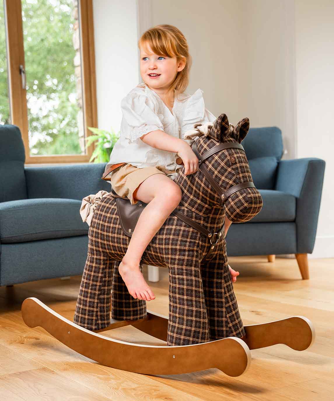 Girl riding brown rocking horse